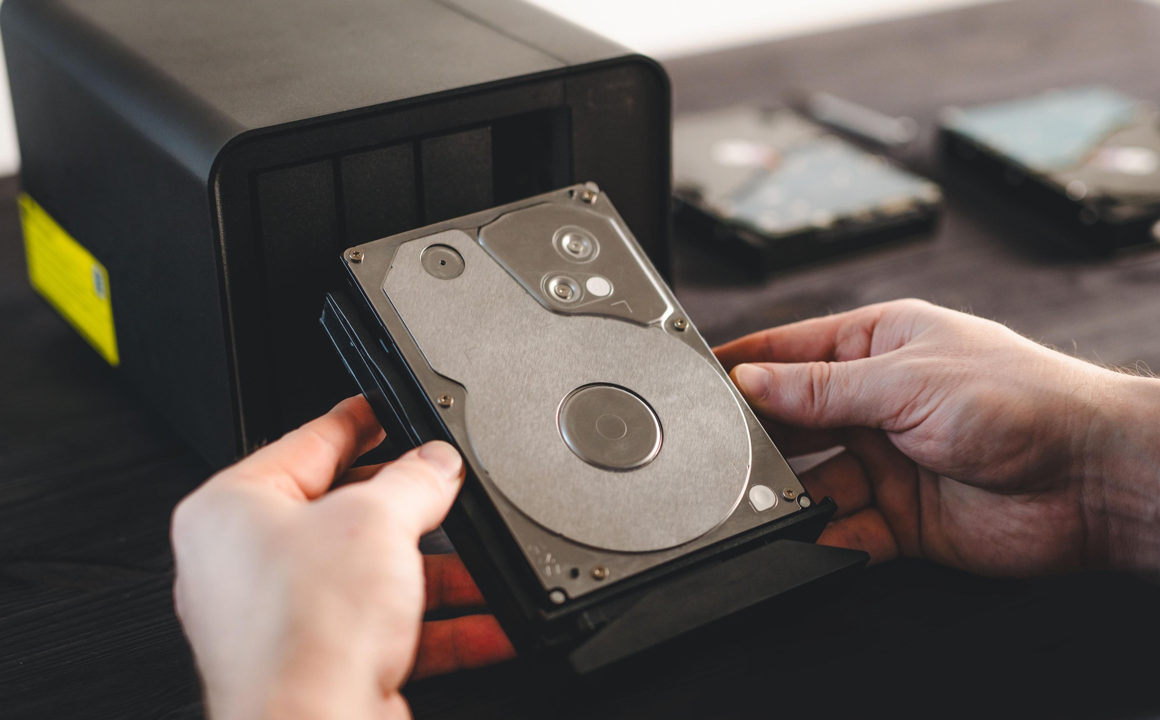 Mains portant un disque dur externe NAS